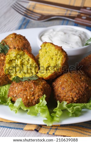 delicious falafel on lettuce leaves with tzatziki sauce close-up on the table. vertical