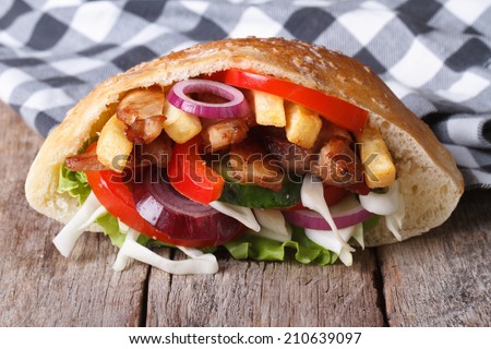 delicious doner kebab with meat, vegetables and fries in pita bread closeup horizontal