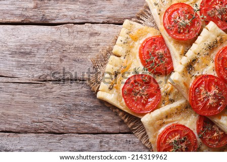 Puff pastry pies stuffed with cheese and tomato close up on a table top view