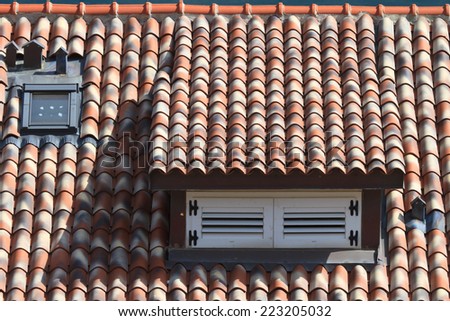 dormer window shuttered in a tile roof, horizontal close-up