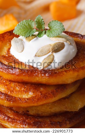 A stack of pumpkin pancakes with sour cream and mint seeds macro. vertical