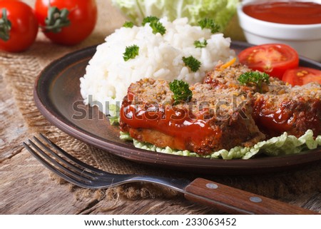 pieces of meat loaf and rice on a plate close-up, horizontal