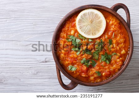 vegetable soup with red lentils and tomatoes close-up on the table. horizontal view from above
