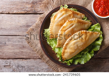 Traditional empanadas on a plate and sauce. horizontal view from above, rustic style