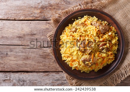 Delicious Asian pilaf on a brown plate. horizontal view from above, rustic style
