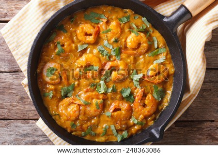 Shrimp in curry sauce in a pan close-up. horizontal view from above