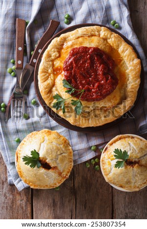 Australian meat pie on a wooden table closeup. vertical view above, rustic style