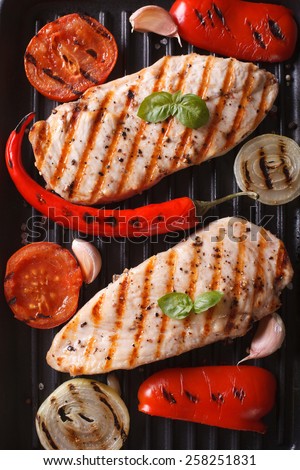 Chicken breast with vegetables in a skillet grill closeup. vertical view from above