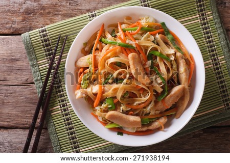 Chow Mein: fried noodles with chicken and vegetables close-up. horizontal view from above