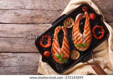 Salmon steak with vegetables on a grill pan. horizontal view from above