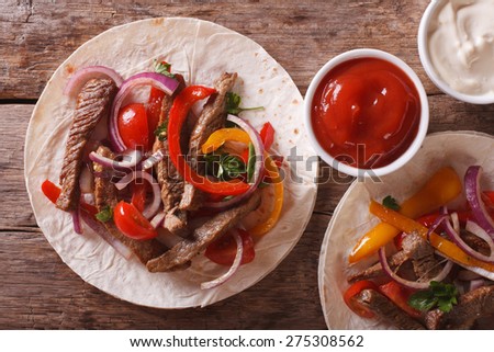 Delicious tortillas stuffed with meat and vegetables close-up. horizontal view from above
