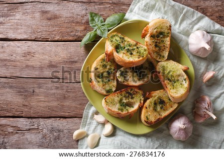 toasted bread with garlic and herbs on a plate. view from above horizontal, rustic style
