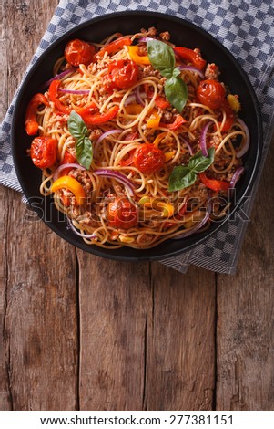 Spaghetti with minced meat and vegetables. vertical view above, rustic style