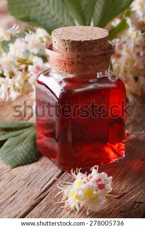 Chestnut tincture of flowers in a bottle on the table. vertical closeup