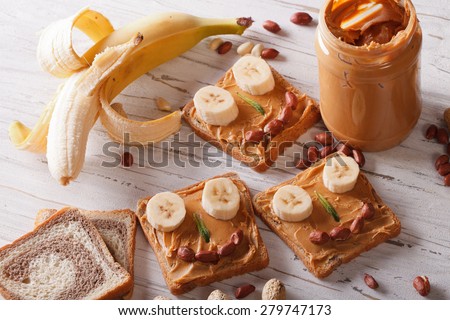 Sandwiches for children with peanut butter and banana on the table. horizontal view from above