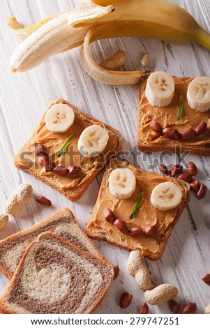 Children sandwiches with peanut butter and banana on the table. vertical top view