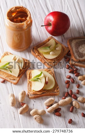 Delicious sandwiches with peanut butter and apple close-up on the table. vertical