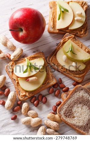 sandwiches with peanut butter and an apple. vertical view from above