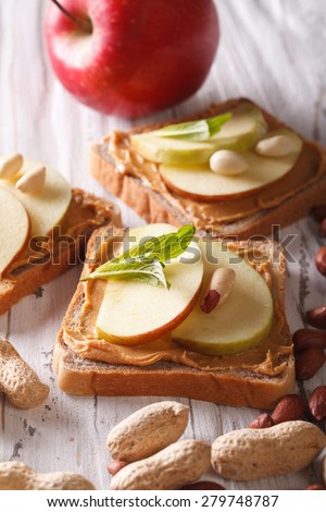 sandwiches with peanut butter and apple close-up on the table. vertical