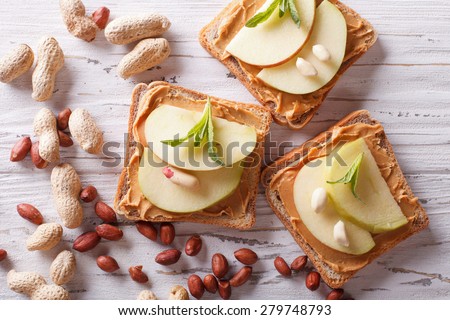 toast with peanut butter and an apple on the table closeup. horizontal top view