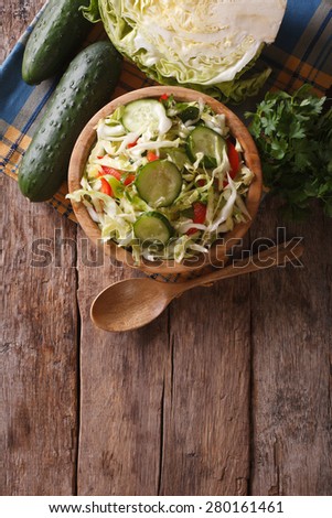 Homemade food: cabbage salad and ingredients on the table, the vertical view from above