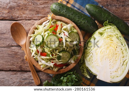 Homemade food: cabbage salad and ingredients on the table, horizontal view from above closeup