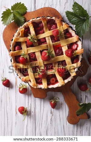 homemade strawberry tart and fresh berries in a baking dish on the table. vertical view from above, rustic
