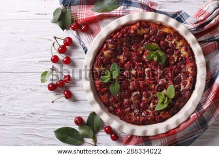 Clafoutis with cherry in baking dish on the table. horizontal view from above, rustic