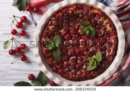 Clafoutis with cherry close-up in baking dish on the table. horizontal view from above, rustic