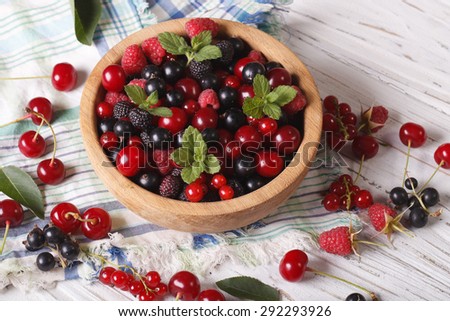Berry mix in a wooden bowl on the table close-up. horizontal