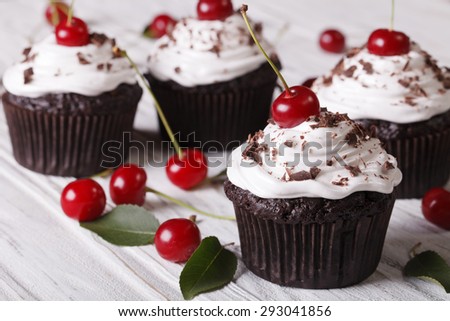 Chocolate cupcakes with cream and fresh cherry Black Forest close up on the table. horizontal