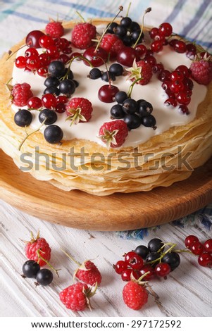 Pile of crepes with berries and cream close-up on a plate. vertical