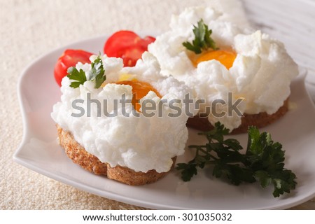 Food gourmet sandwiches with baked eggs Orsini and tomatoes on a plate close-up. horizontal