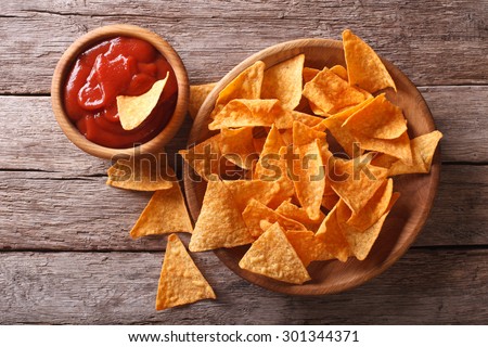 Nachos corn chips with spicy sauce on the table. horizontal view from above