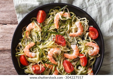 Dietary food: zucchini pasta with shrimp and tomato on a plate close-up. horizontal view from above