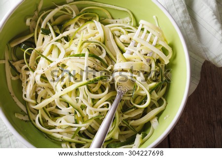 Dietary zucchini pasta in a bowl closeup on the table. horizontal view from above