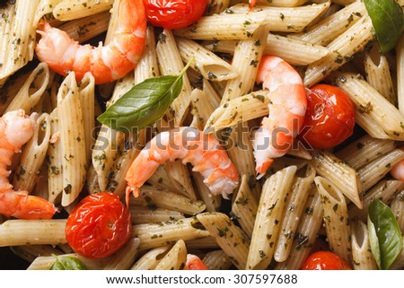 Food background: pasta with shrimp and pesto sauce on a plate macro. horizontal view from above