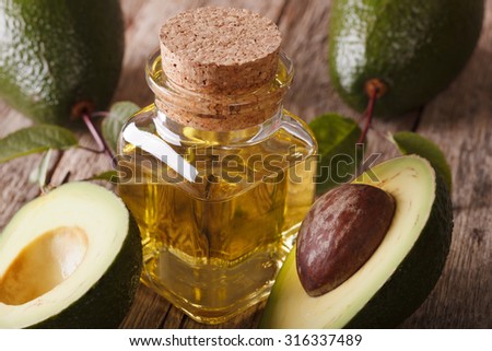 fresh avocado oil in a glass bottle on a wooden table macro, horizontal