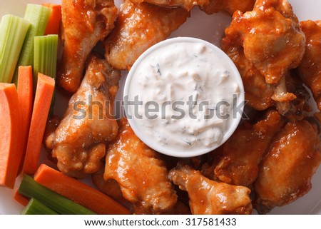 Buffalo wings with sauce on a plate macro. horizontal view from above