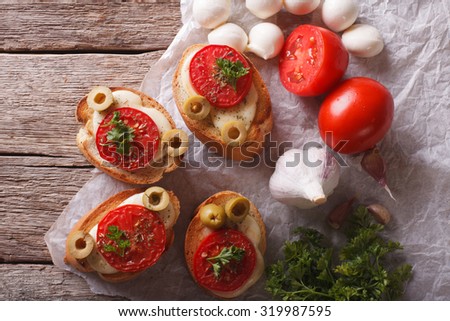 crostini with tomatoes, olives and cheese close-up on the table. horizontal view from