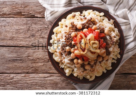 Arabic cuisine: kushari of rice, pasta, chickpeas and lentils on a plate horizontal top view