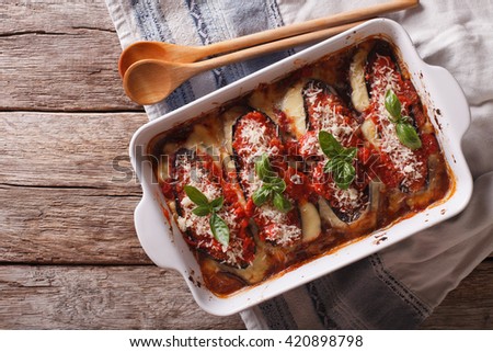 Italian eggplant baked with mozzarella in tomato sauce close up in baking dish. horizontal view from above