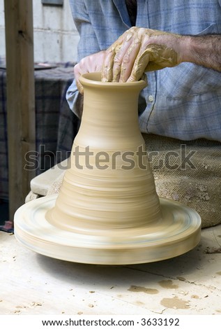 Potter shaping clay on a potter\'s wheel