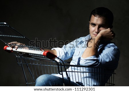 young man sitting in shopping cart