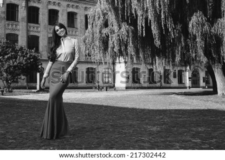 young woman in formal clothes near old university building  black and white photo