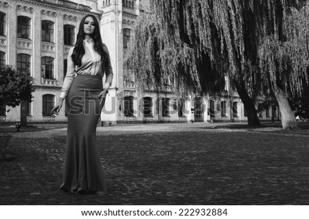young woman in formal clothes near old university building  black and white photo