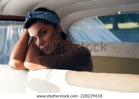 pin-up lady with tattoos in retro car