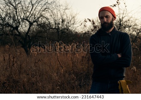 lumberjack in apple orchard standing in the rays of the autumn sun