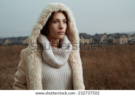 woman standing in fields behind country town
