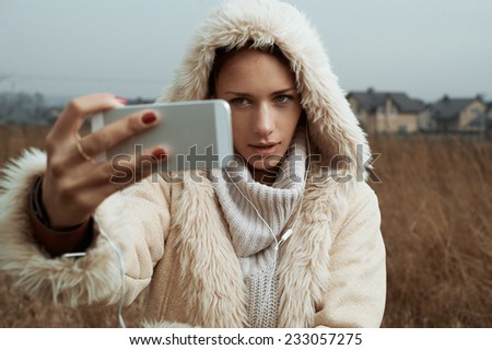 woman takes selfies in fields behind country town